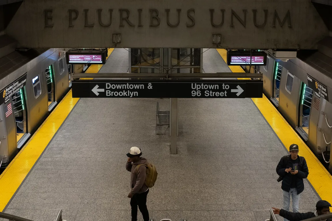 Two new tech trains (R211, right; R143, left) at the platform at 86 St 2 Av, shot from the stairwell down to the platform.