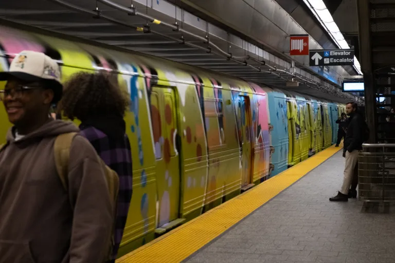 A very colorfully graffitied R46 set passes through 86 St 2 Av station