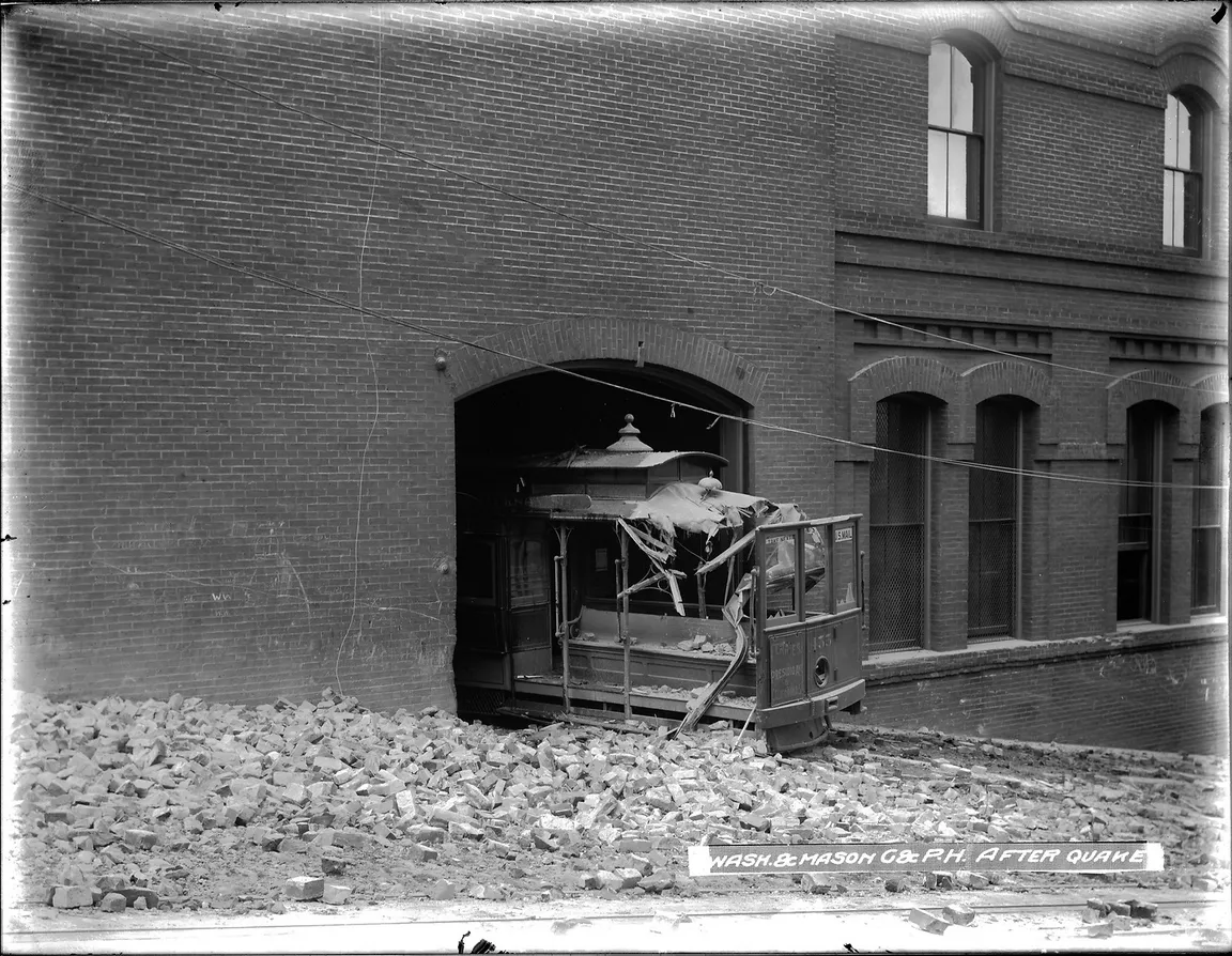 A cable car emerges from the Washington and Mason Carbarn immediately after the 1906 earthquake with rubble on it's roof.