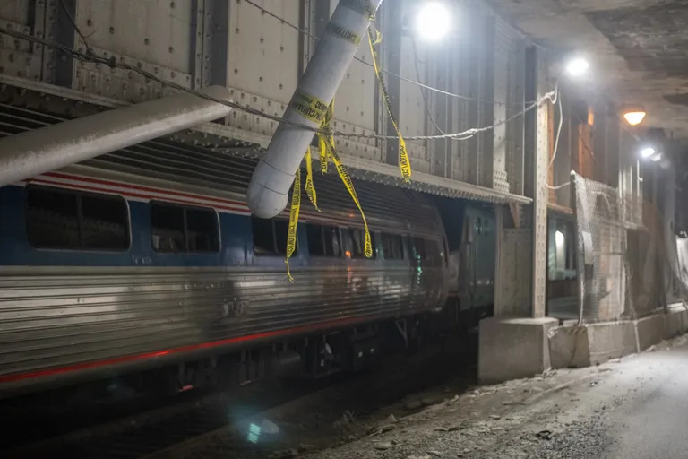 An ACS-64 electric Amtrak locomotive going away from the camera to the right, towing a single former Metroliner Amfleet cab car.