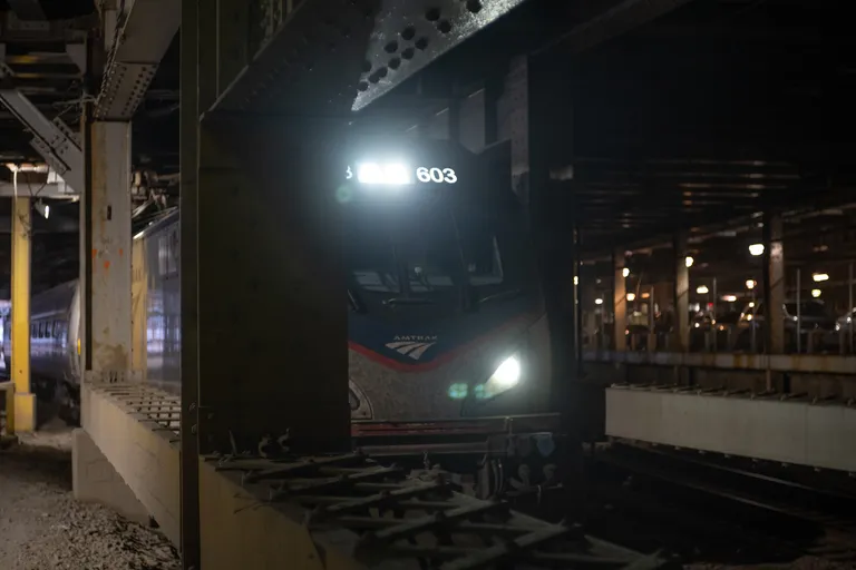 A super close shot of the front of an ACS-64 electric Amtrak locomotive, with headlights on.